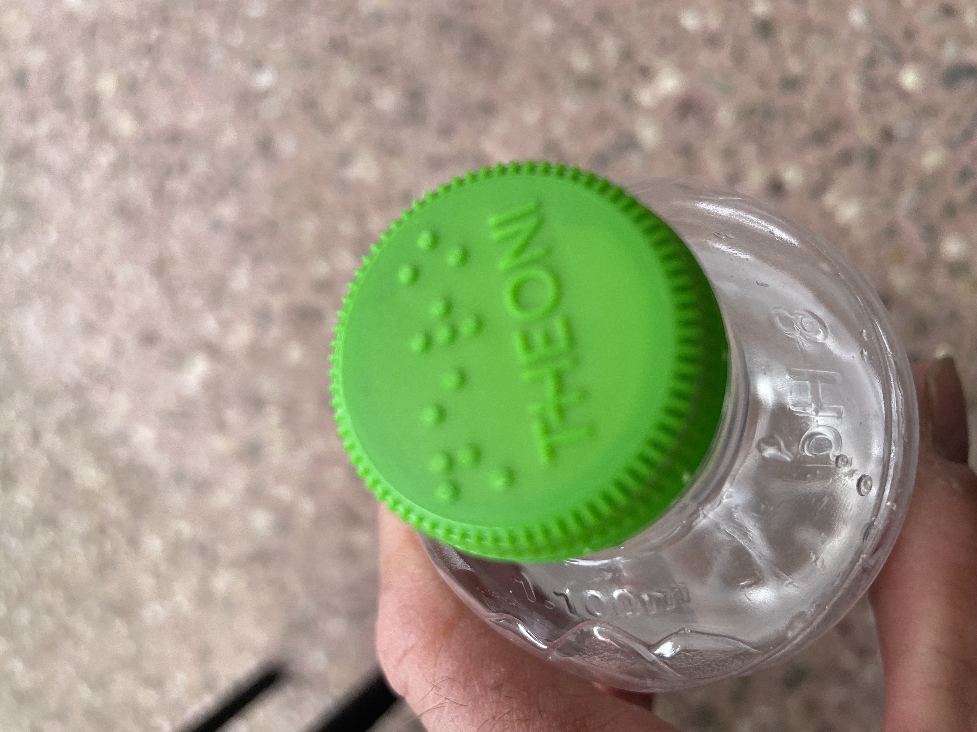 Water bottle with the braille label 'nero', or 'water'.